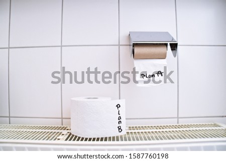 Finding a way out of the failure of a plan represented by an empty toilet paper roll, on which plan A was written, and other full toilet paper rolls that symbolize other plans 