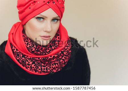 Photo of self assured Arabian lady in hijab, shows you right way, points at blank space with both fore fingers, invites going there, promots copy space. Check it out with me.