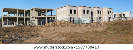 The building of unfinished rural eco  houses  from white bricks on sand hill . Sunny winter day panoramic landscape from several outdoor photos