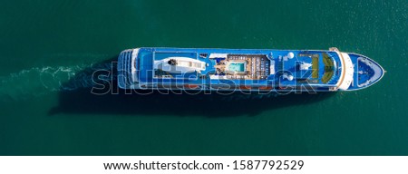 Aerial top view photo of luxury cruise ship sailing from port across The Mediterranean sea. Summer vacation concept: Hi class Cruise ship on Caribbean Sea.