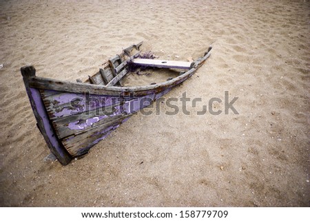 Color picture of an abandoned boat stuck in sand