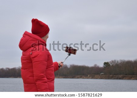 girl takes a selfie by the river in cold