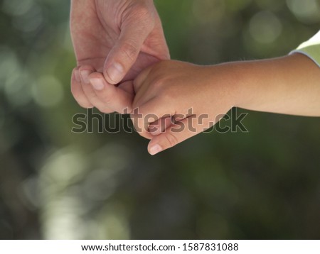 Close up of father and child holding hands