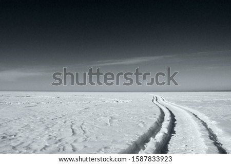 footprints in the snow from a snowmobile, black and white picture, poster