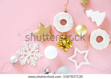 Christmas composition. Top view of Christmas tree decorations snowflakes, stars, balls, donuts of gold, white and silver on a pink background. Flat lay.