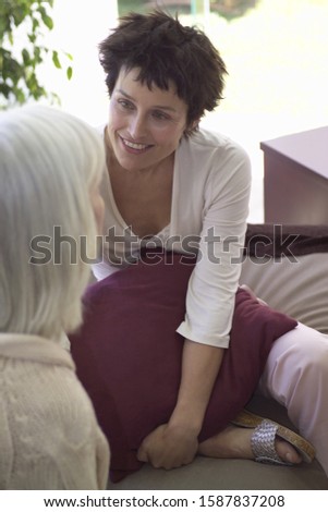 Middle-aged female couple talking on sofa