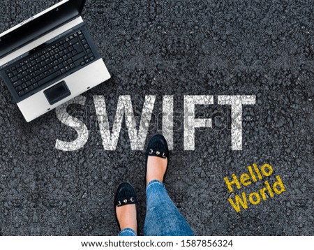 Swift programming language. A woman steps to a laptop and word Swift on asphalt.