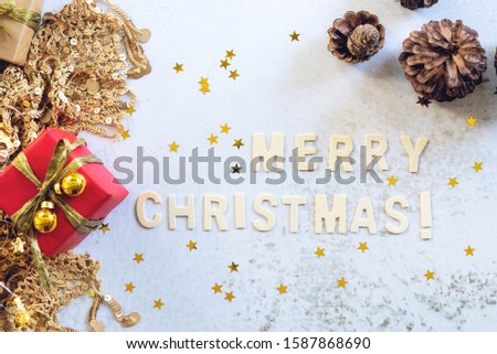 Merry Christmas text with red gifts box,  and shining golden decoration star flakes, X mass and happy new year background.