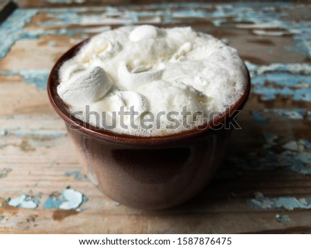 Cappuccino with marshmallows in a cup on an old wooden background. New Year's still life.