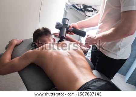 Therapist Treating Injury of Professional Athlete Male Patient - Sport Physical Therapy Concept. Massage and Sports Physio Therapy. - Photography Royalty-Free Stock Photo #1587887143