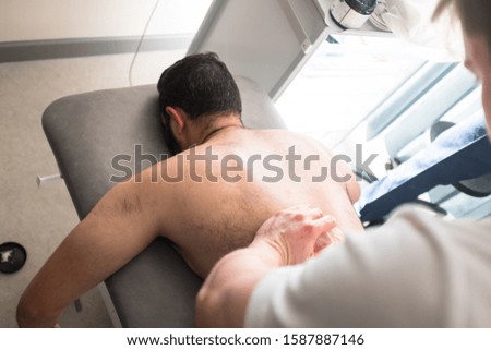 Therapist Treating Injury of Professional Athlete Male Patient - Sport Physical Therapy Concept. Massage and Sports Physio Therapy. - Photography