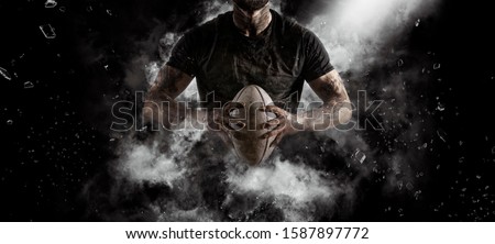 Rugby player in action on dark arena background Royalty-Free Stock Photo #1587897772