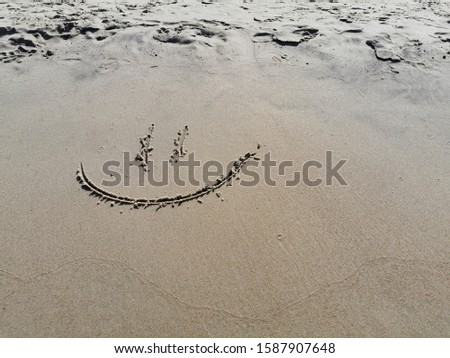 Smile on the sand. Smile face on sand. Smile face in the sand on a beach.