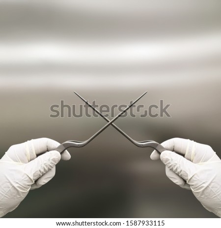 Surgeon Holding Two Bayonet Forceps With White Gloved Hands
