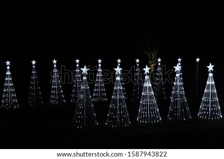 Fifteen white LED and wire Christmas tree decorations against a black night background