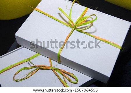 white, gift boxes on a black table.