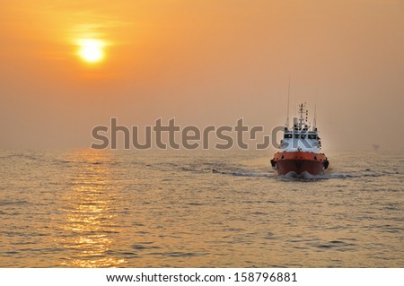 Offshore Boat for Crew Change Before Sunset With Stunning Golden Sky Royalty-Free Stock Photo #158796881