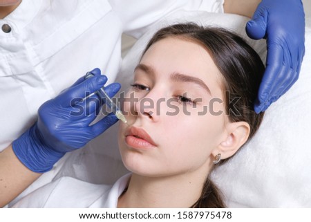 stabbing lips. Beautician doctor enlarges lips by injection. Fillers