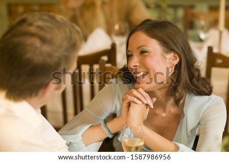 Woman smiling at boyfriend at restaurant table