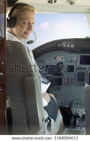 Female pilot in cockpit of airplane