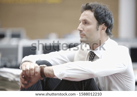 Close up of businessman sitting with arms on knees