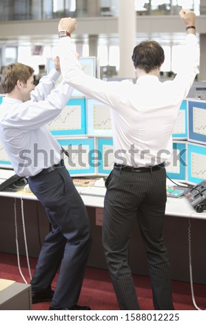 Two businessmen cheering in office
