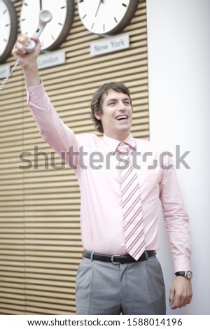 Businessman holding telephone receiver in hand and smiling