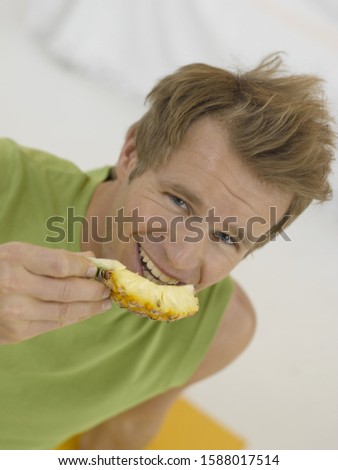 High angle view of man eating pineapple