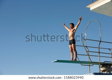 A diver standing on a diving board Royalty-Free Stock Photo #1588023940
