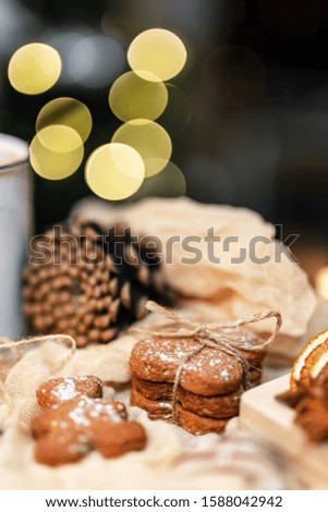 Gingerbread cookies in front of the blurred lights. White christmas tree decorations.