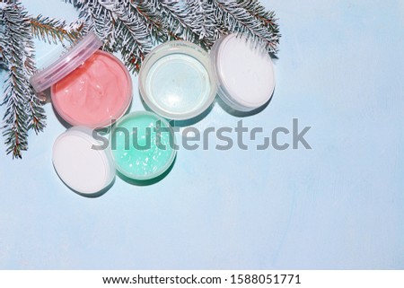 Spa salon, Sale, a set of creams for winter skin care on the background of fir branches. Shopping concept and modern woman,