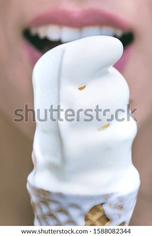 Picture of a woman eating ice cream in waffle cone.
