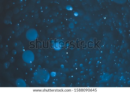 Abstract bokeh lights with blue and black background. Beautiful bokeh from water droplets.
