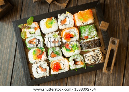 Traditional japanese food on a dark wooden background. Sushi rolls. Asian food frame. Dinner party. Top view image
