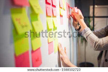 project management, agile methodology. young business woman in the office are planning product development and support. Project manager glue sticky stickers on the Board Royalty-Free Stock Photo #1588102723
