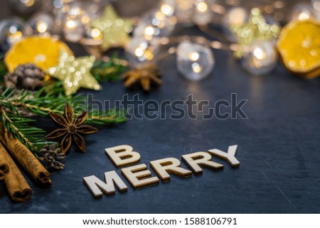 Be merry and red spiced wine winter holiday still life concept on dark slate board with dried oranges, anise stars, cinnamon sticks and evergreen sprigs