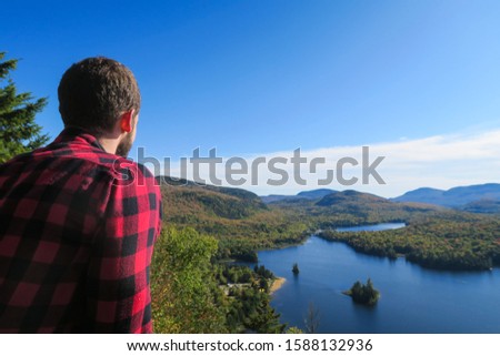Lumberjack admiring the beautiful  Monroe lake at Mont-Tremblant national park 