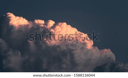 Dramatic cloudy sky at sunset. Scenic picture of clouds hitten by sunlight at dusk.