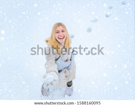 Outdoor photo of young beautiful happy smiling girl walking on white snow Background. Beautiful woman enjoying first snow