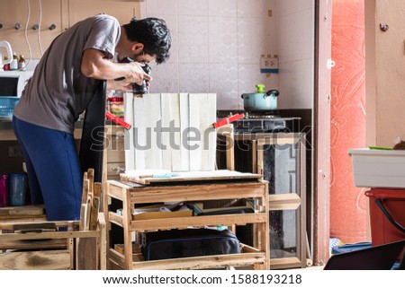 Professional photographer taking a photo with simple natural light studio set up inside kitchen in a narrow space.