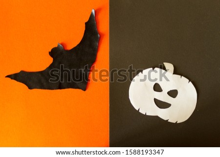 Halloween concept image. Pumpkin and bat on orange background