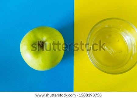 Apple juice on colorful background. Apple ad glass