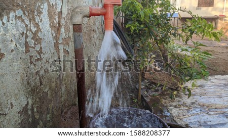Sweet drinking water being filling into a plastic gallon cause of water crisis. Flowing water in wastage.