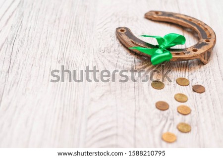 horseshoe, coins and bells on a light wooden table. A symbol of good luck.