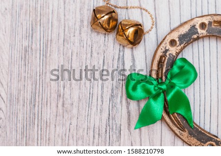 horseshoe, coins and bells on a light wooden table. A symbol of good luck.