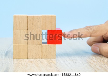 Hand choose cube shape wooden block toy stacked without graphics for Business design concept and activity for child foundation practice skills.