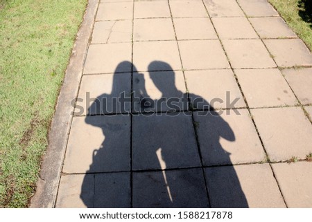 A man and a woman shadows on the cement floor, Family travel on weekend