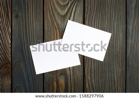 Two blank cards (business cards, tickets, flyers, invitations, coupons, banknotes, etc.) on dark wooden background