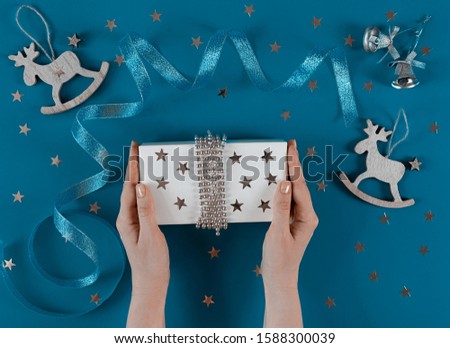 Christmas background, banner, postcard with Xmas toys and gift on classic blue canvas background. The theme of a winter holiday. happy New Year. Space for text. Flat lay.