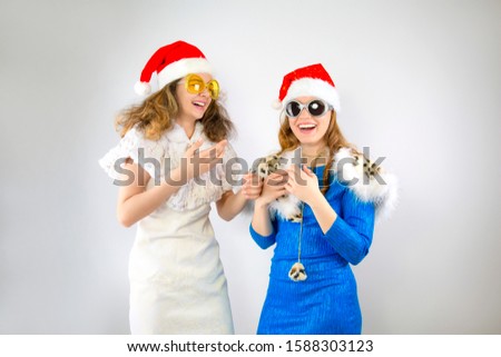 Happy laughing women in Santa hats having fun isolated on gray backdrop Happy New Year 2020 celebration holiday concept. Mock up copy space.